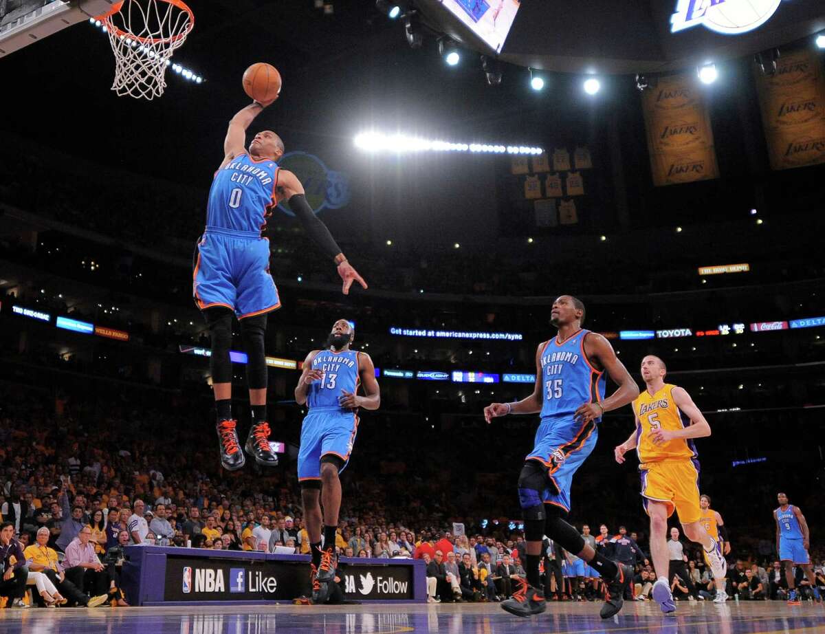 Oklahoma City Thunder guard Russell Westbrook, left, goes up for a dunk as guard James Harden, second from left, forward Kevin Durant, second from right, and Los Angeles Lakers guard Steve Blake look on during the second half in Game 3 of an NBA basketball playoffs Western Conference semifinal, Friday, May 18, 2012, in Los Angeles. The Lakers won 99-96. (AP Photo/Mark J. Terrill)
