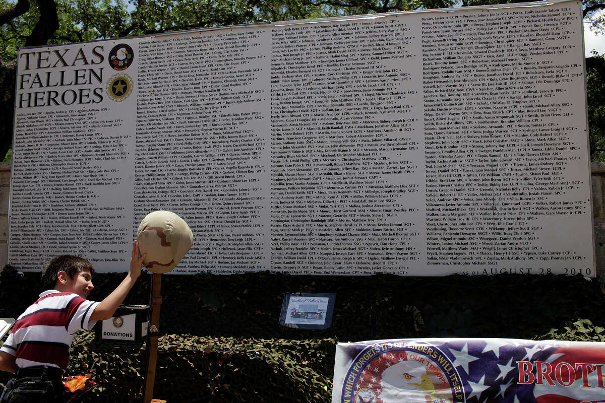 Angel Galindo, 8, of Laredo, looks at the Brothers of Fallen Heroes' Texas Fallen Heroes Memorial Wall display at La Villita in San Antonio on Saturday, May 19, 2012.