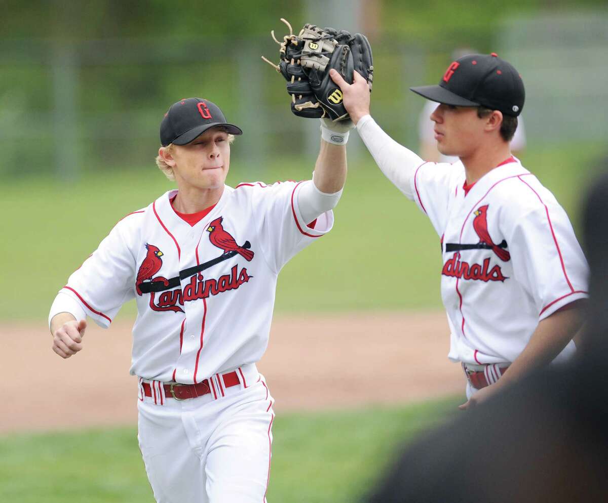 Second baseman Max Pruner, left, of Greenwich, high-fives teammate Dylan Callahan following a 4-0 win over McMahon. The undefeated Cardinals are the top seed in the FCIAC tournament.