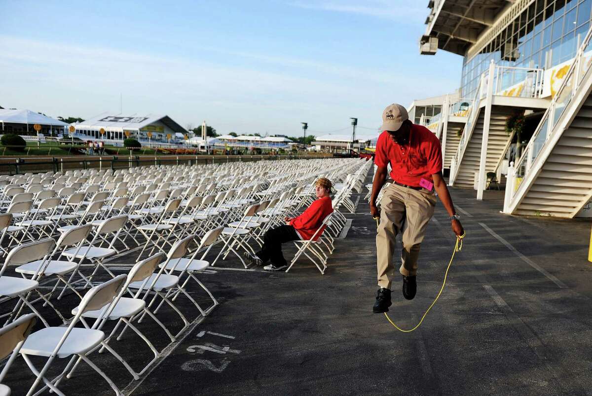 A security guard jumps with a gate rope before the gates are opened to the public prior to the 137th running of the Preakness Stakes at Pimlico Race Course on May 19, 2012 in Baltimore, Maryland.