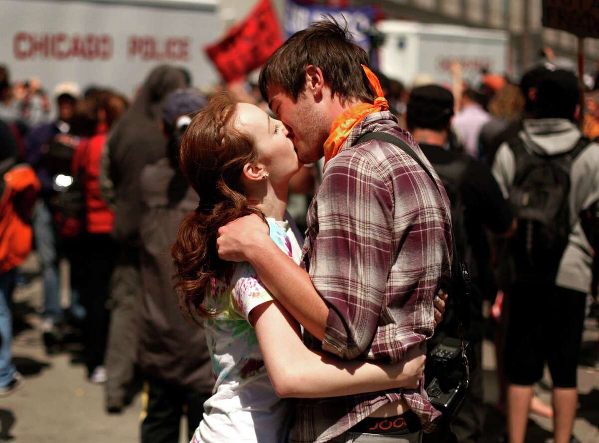 Alex Kennedy, left, from Geneva, Ill., and Dillon Roberts, from Bartlett, Ill., kiss after a demonstration and march to President Barack Obama's campaign headquarters in Chicago on Monday, May 21, 2012, the final day of the NATO summit. (AP Photo/Charles Rex Arbogast)