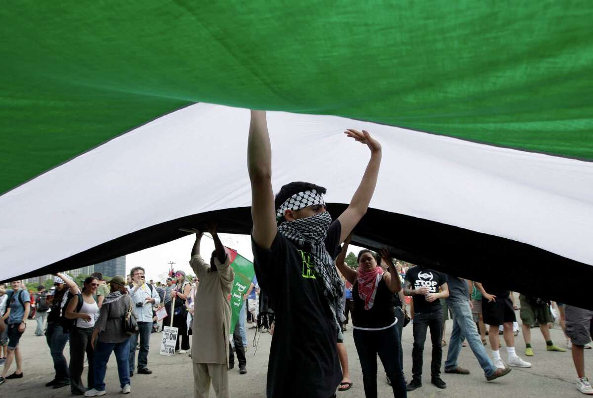 Demonstrators carry the Palestinian flag during a protest march in Chicago during this weekend's NATO summit Sunday, May 20, 2012 in Chicago. (AP Photo/Nam Y. Huh)