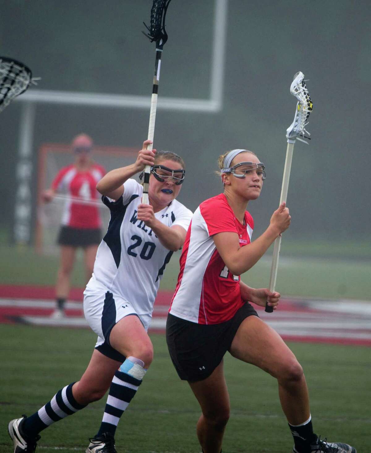 Wilton's Megan Boepple closes in on Greenwich's Emily Johnson as Greenwich and Wilton face off in the FCIAC Girls Lacrosse Semifinals at Dunning Field in New Canaan, Conn., May 21, 2012.