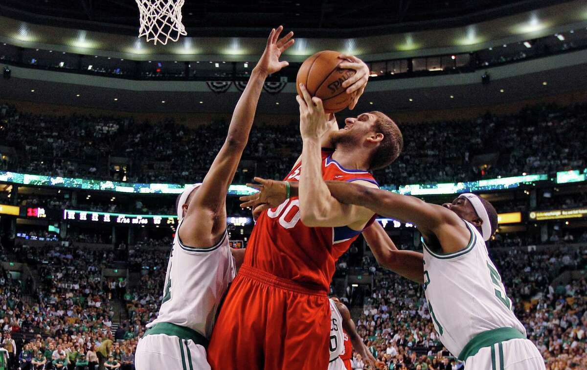 Philadelphia 76ers center Spencer Hawes is tied up by Boston Celtics point guard Keyon Dooling, right, and forward Paul Pierce, left, during the second half of Game 5 in their NBA basketball Eastern Conference semifinal playoff series in Boston, Monday, May 21, 2012. The Celtics won 101-85. (AP Photo/Charles Krupa)