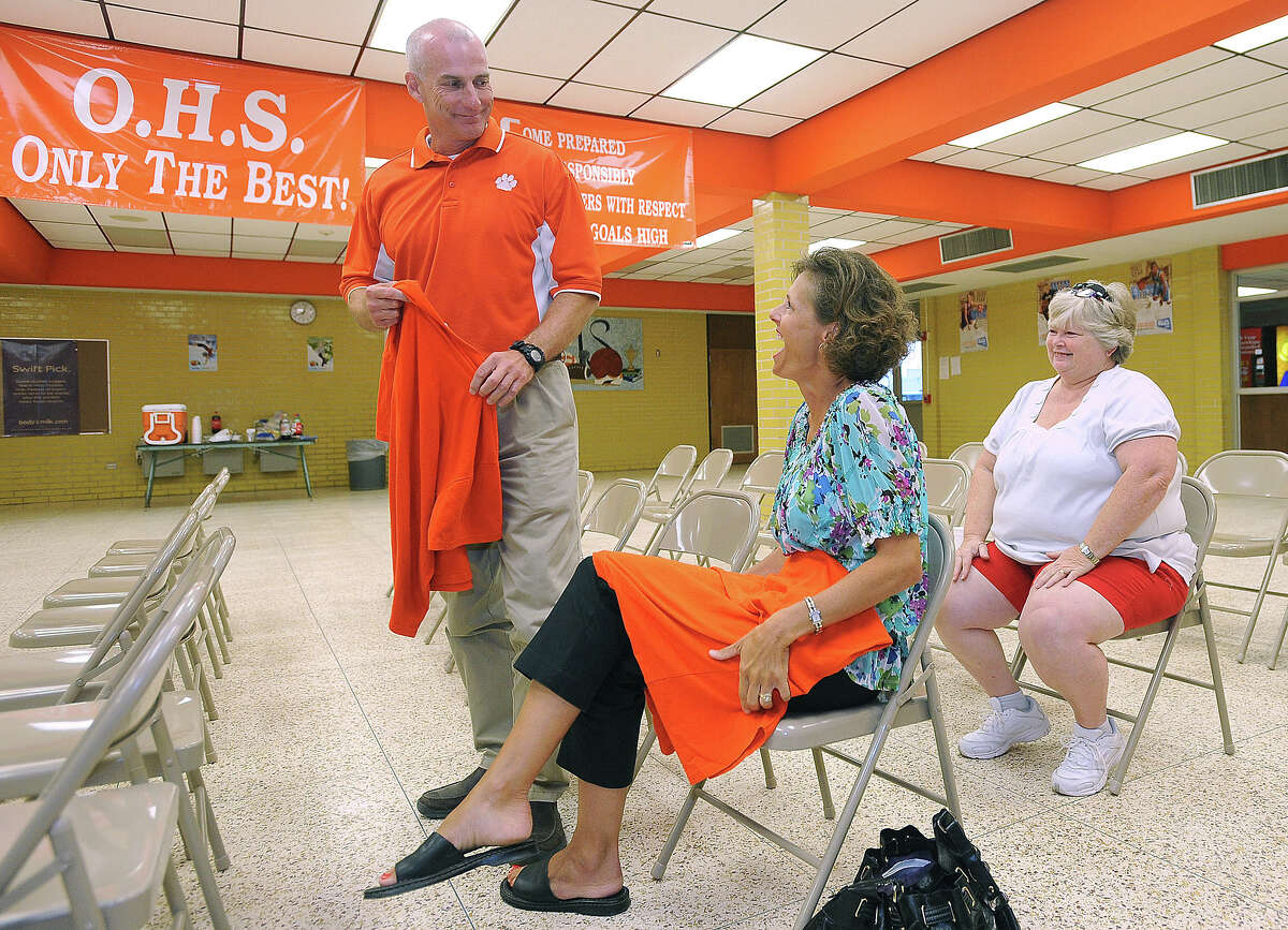 Brian Huckabay looks at his wife Mary Huckabay after being appointed the new head coach for Orangefield High School at the school's cafeteria Monday night. Guiseppe Barranco/The Enterprise