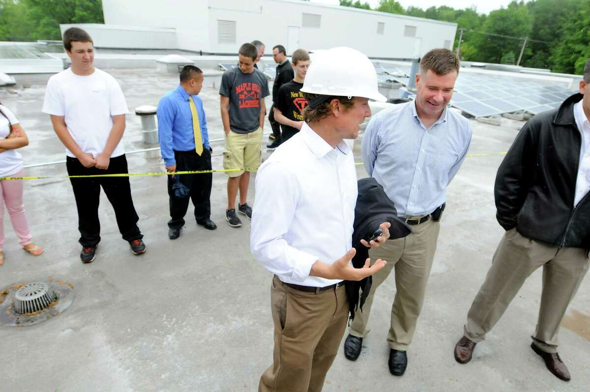 U.S. Rep. Chris Gibson, right, and Tyler Justin, director of field operations with Monolith Solar Associates, center, talk about energy advances the school district has made on Tuesday, May 22, 2012, on the roof at Schodack High in Schodack, N.Y. (Cindy Schultz / Times Union)