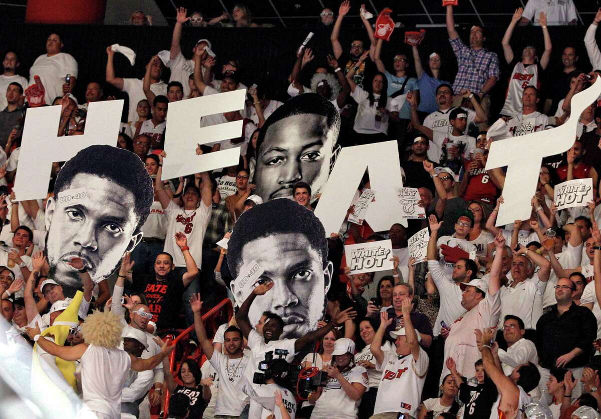 Fans hold up cutout heads of Miami Heat's Udonis Haslem, left, and Dwyane Wade, rear, during the second half of Game 5 of an NBA basketball Eastern Conference semifinal playoff series between the Heat and the Indiana Pacers in Miami, Tuesday, May 22, 2012. The Heat won 115-83 to take a 3-2 series lead. (AP Photo/Lynne Sladky)