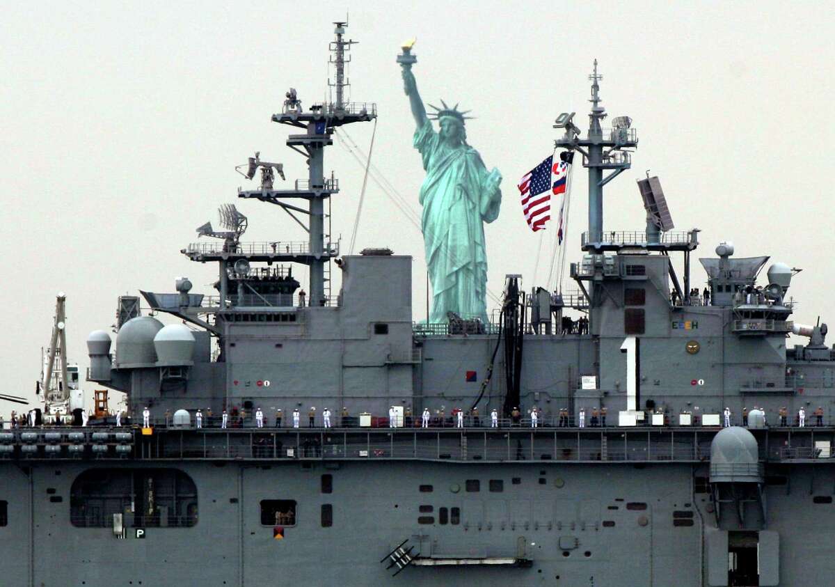 Sailors line the deck of the USS Wasp as she sails by the Statue Of Liberty, in New York, to participate in Fleet Week activities, Wednesday, May 23, 2012.