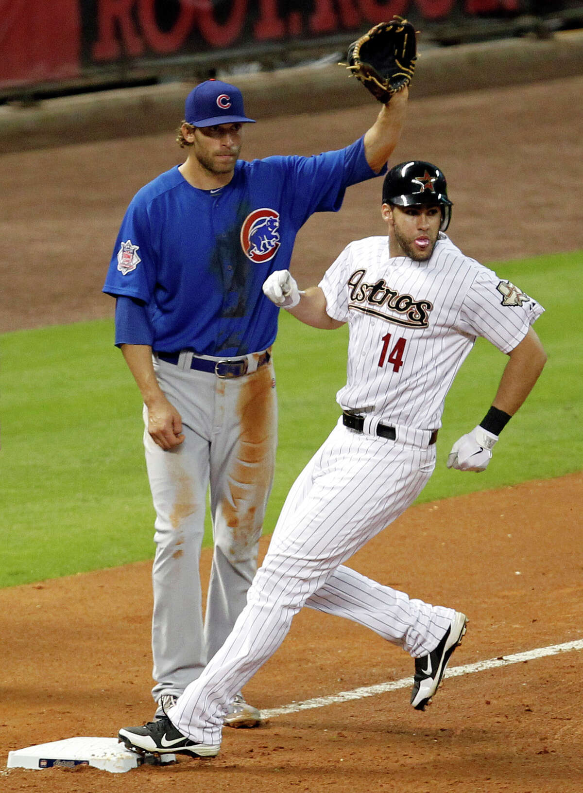 The Chicago Cubs third baseman Joe Mather, left, looks on as the Houston Astros left fielder J.D. Martinez stops at third base after hitting a triple during the fourth inning of MLB game action at Minute Maid Park Wednesday, May 23, 2012, in Houston.