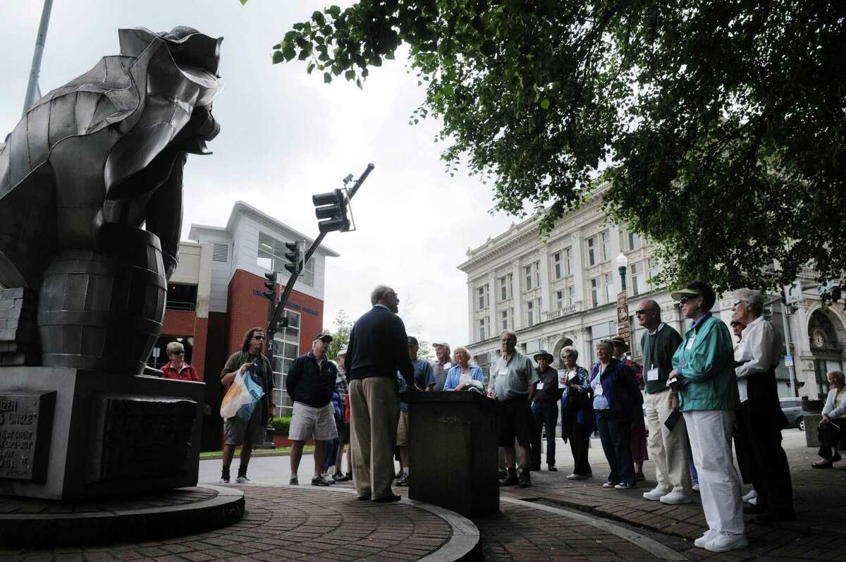 Tom Carroll, center, of the Hudson Mohawk Gateway, stands near the Sam Wilson statue as he leads a tour for passengers from the cruise ship Grande Mariner on Wednesday, May 23, 2012 in Troy, NY. The cruise ship, which is run by Blount Small Ship Adventures, docked along Riverfront Park in downtown Troy for the first time since last years flooding forced the ships to dock in Albany instead. (Paul Buckowski / Times Union)
