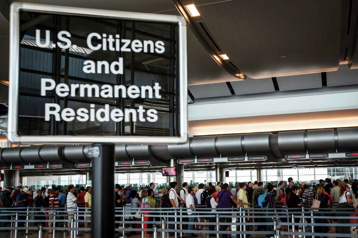 People wait in line at the Federal Inspection Services customs facility at Bush Intercontinental Airport in Terminals E, Wednesday, May 23, 2012, in Houston.