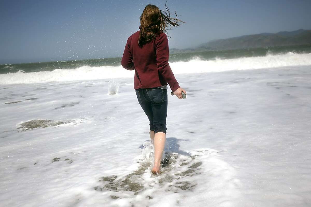 Angella Miller of Chicago walks out into the water to skip rocks at Baker Beach. Heal the Bay released it's annual report on California beaches and water quality at Baker Beach in San Francisco Thursday May 24th, 2012