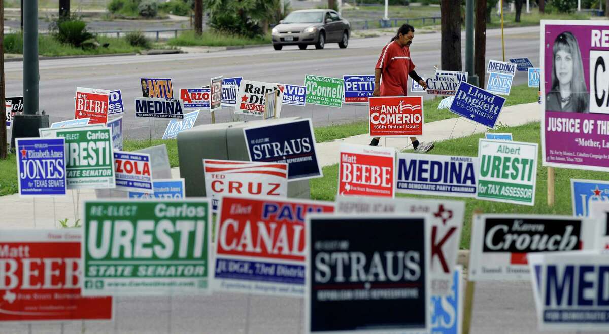A man walks through a sea of election signs at an early voting polling site on Wednesday in San Antonio. Election day in Texas is today, May 29.
