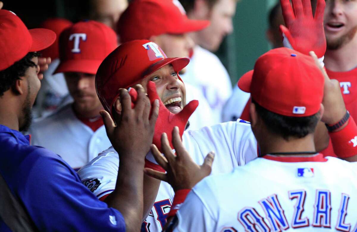 Texas Rangers Yorvit Torrealba celebrates in the dugout with teammates after hitting a solo home run during the third inning of a baseball game against the Toronto Blue Jays Friday, May 25, 2012, in Arlington, Texas.
