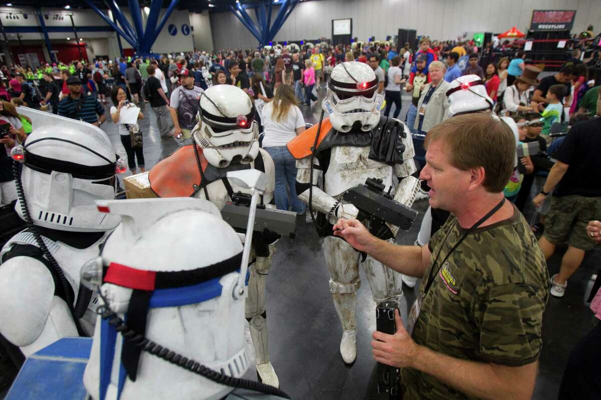 Members of the 501st Legion dressed as Stormtroopers from Star Wars listen as John Pittman, right, explains the rules of laser tag played at the Battlefield Houston booth at Comicpalooza at the George R. Brown Convention Center Saturday, May 26, 2012, in Houston.