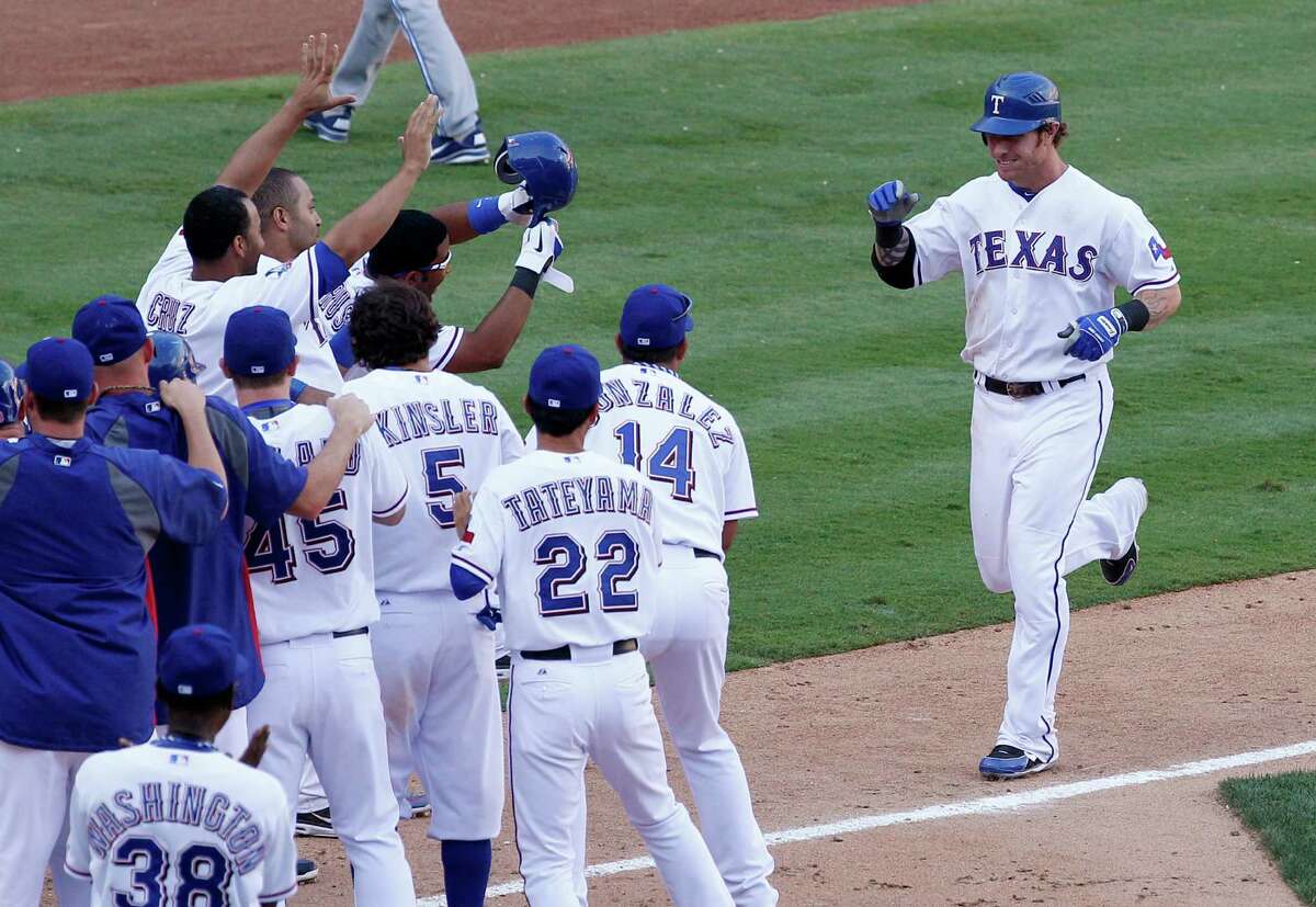 Texas Rangers' Josh Hamilton, right, is greeted at home by teammates following his two-run walkoff home run off Toronto Blue Jays' Jason Frasor in the 13th inning of a baseball game on Saturday, May 26, 2012, in Arlington, Texas. The Rangers won 8-7.