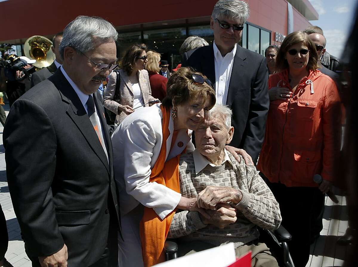 Rep. Nancy Pelosi hugs Gus Villalta, an ironworker who helped build the Golden Gate Bridge 75-years ago, as Mayor Ed Lee looks on during a dedication ceremony for the new Bridge Pavilion in San Francisco, Calif. on Friday, May 25, 2012. The event kicked off a weekend of events to celebrate the iconic bridge's 75th anniversary.