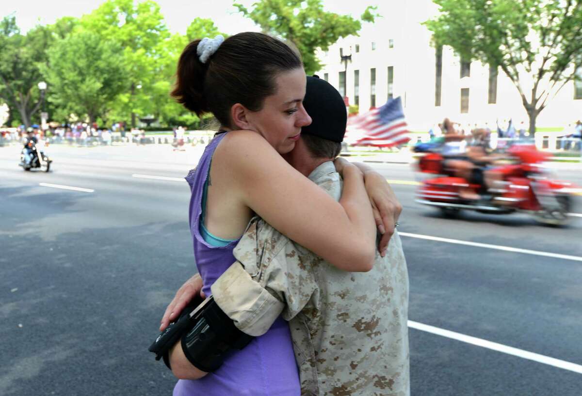 A US veteran soldier, who was injured while serving in Iraq, is comforted by his girlfriend as motorcyclists pass by during the Rolling Thunder 2012 in Washington, DC, on May 27, 2012. The 25th annual Rolling Thunder rumbled into town to show support for veterans past and present, those who have fallen in war and those who are missing in action. It's expected nearly one million riders will be here through Memorial Day.