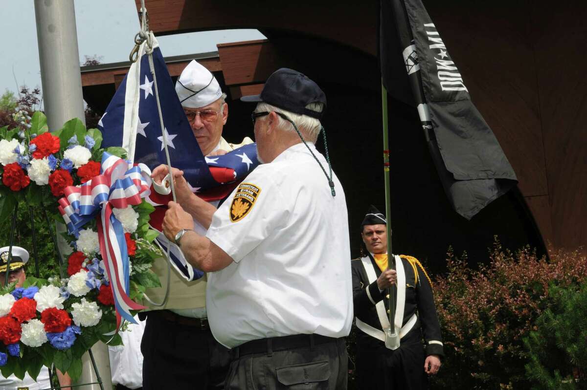 Byram veterans past commanders Don Merchant, left, and Joe Kralik raise the American flag at the ceremony during the Byram Veterans Association's annual Memorial Day parade on Sunday, May 27, 2012.