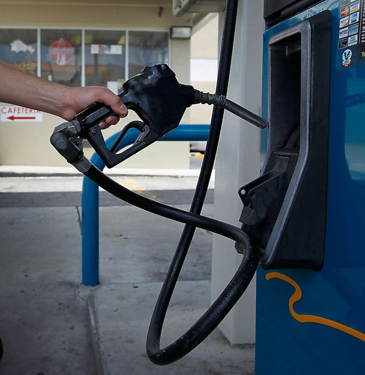 MIAMI, FL - MAY 11: Raciel Henry replaces the gas pump handle after filling up his motorbike with fuel at a Valero station on May 11, 2012 in Miami, Florida. Reports indicate that gasoline prices have dropped 5 percent since peaking last month. The national average fell to $3.739 per gallon on Thursday, down nearly 20 cents since hitting a high of $3.936 on April 6. (Photo by Joe Raedle/Getty Images)
