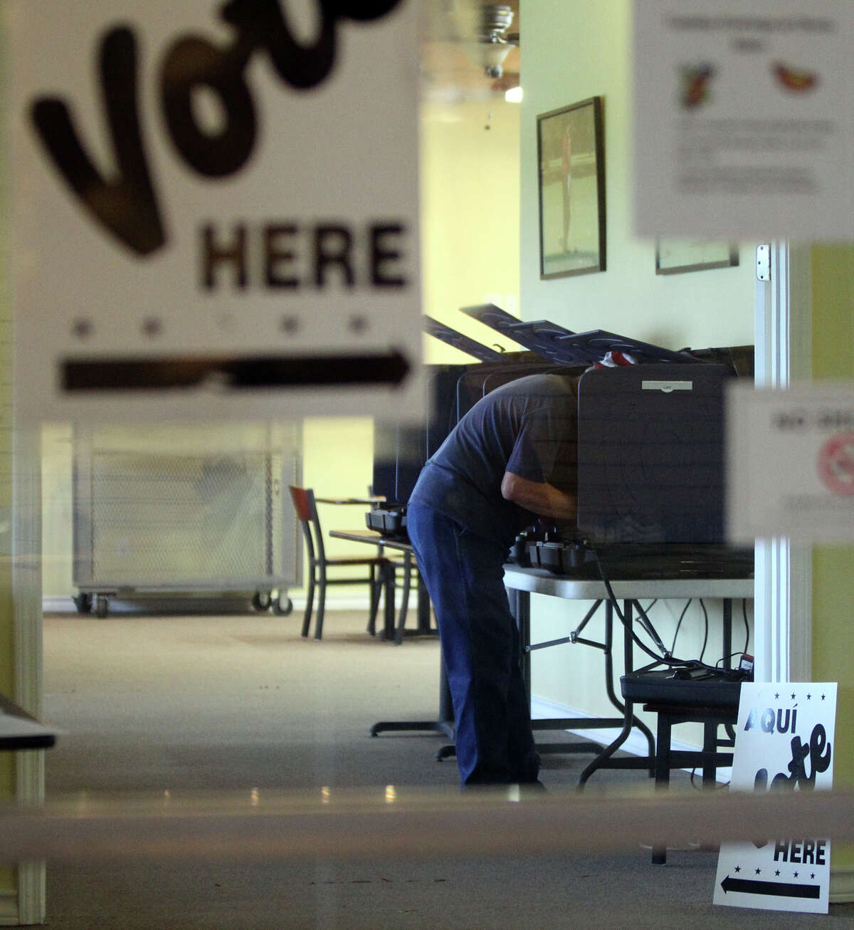 A man leans into a voting booth Tuesday, May 29, 2012, at the Olmos Basin Golf Course a few minutes after 7 a.m.
