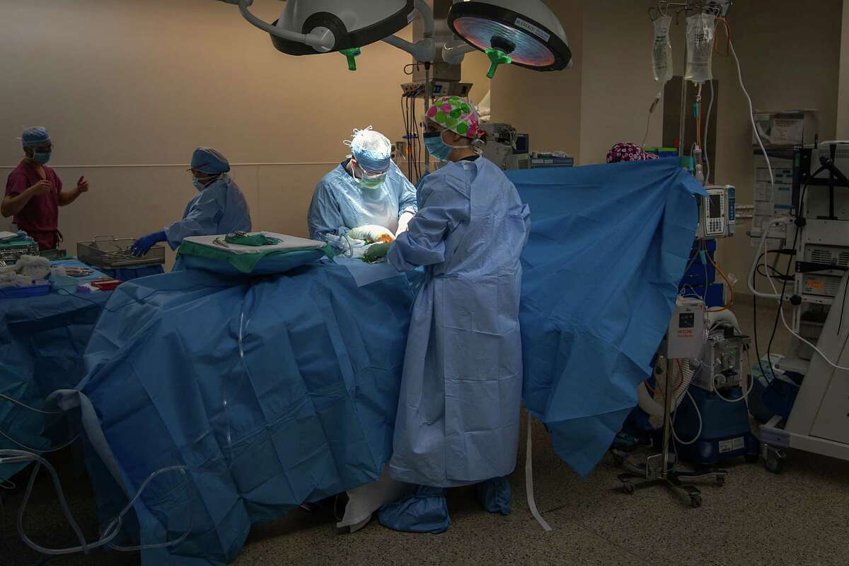Trauma surgeons perform surgery on a gunshot victim in an operating room in the emergency center at Memorial Hermann Hospital on Saturday, May 26, 2012, in Houston.