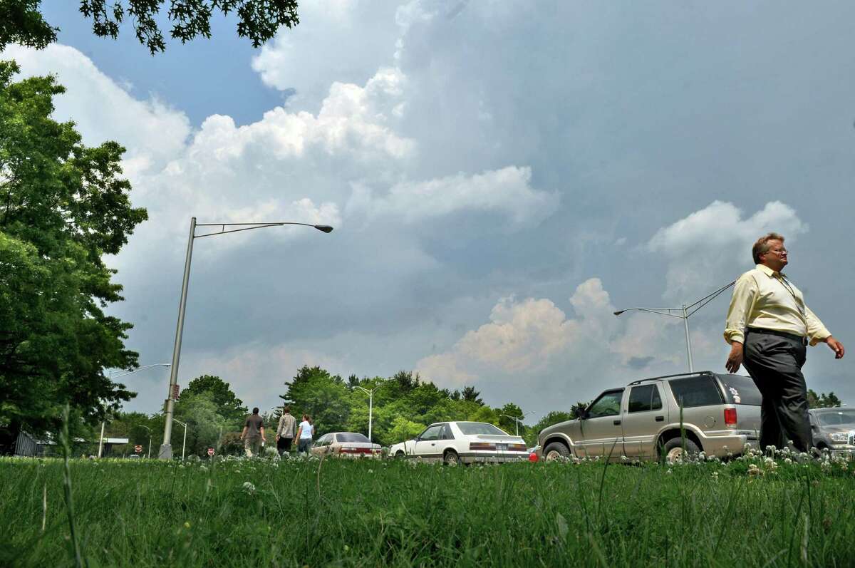 Storm clouds loom in the distance as a pedestrian walks on the Harriman State Office campus on Tuesday May 29, 2012 in Albany, NY. A tornado watch was issued for Tuesday afternoon. (Philip Kamrass / Times Union )