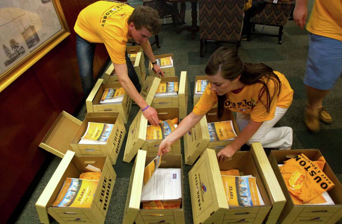Sam Roecker, left, and Monica del Rio, right, sort through boxes containing copies of over 33,000 signatures in favor of a petition to allow Southwest Airlines to fly internationally from Hobby Airport.