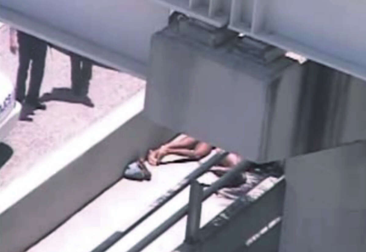 In this image taken from video, Miami police officers stand watch near a naked man, second from right, who was shot dead by a police officer when he refused to stop chewing on the face of the naked man next to him, partially obscured by a railing, on the MacArthur Causeway ramp onto Northeast 13th Street in Miami, Saturday, May 26, 2012. The victim was taken to a nearby hospital. Police say neither man's identity is known. (AP Photo/The Miami Herald) MAGS OUT
