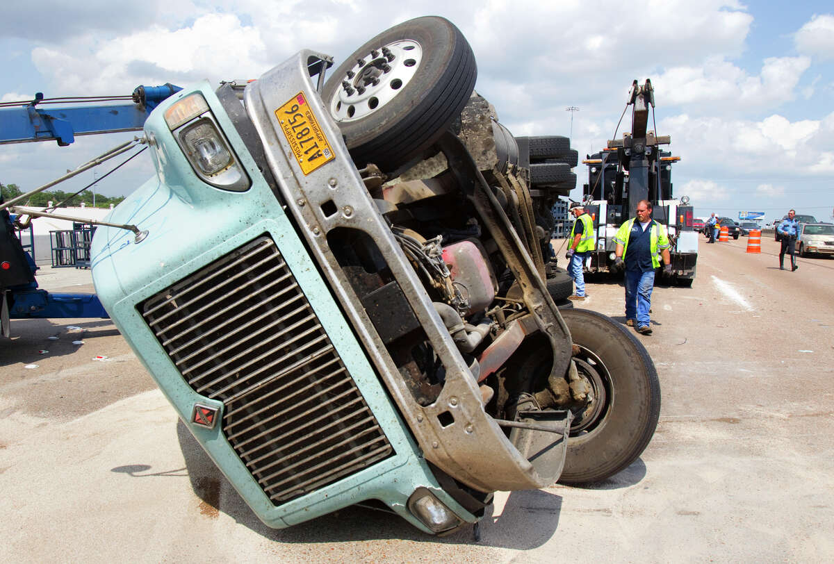 Crews work the scene of an overturned 18-wheeler in the westbound lanes of I-10 Wednesday, May 30, 2012, in Houston. The wreck blocked all but one lane, snarling traffic.