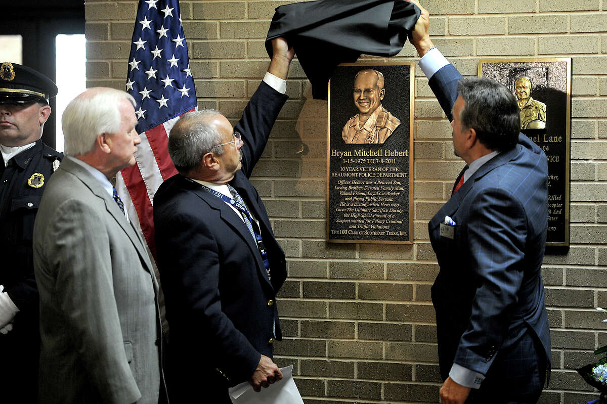 Beaumont Police Chief James Singletary, left, and John Reaud, with The 100 Club of Southeast Texas unveil a bronze memorial plaque of fallen-officer Bryan Hebert at the Beaumont Police Station on Wednesday. Photo taken Wednesday, May 30, 2012 Guiseppe Barranco/The Enterprise