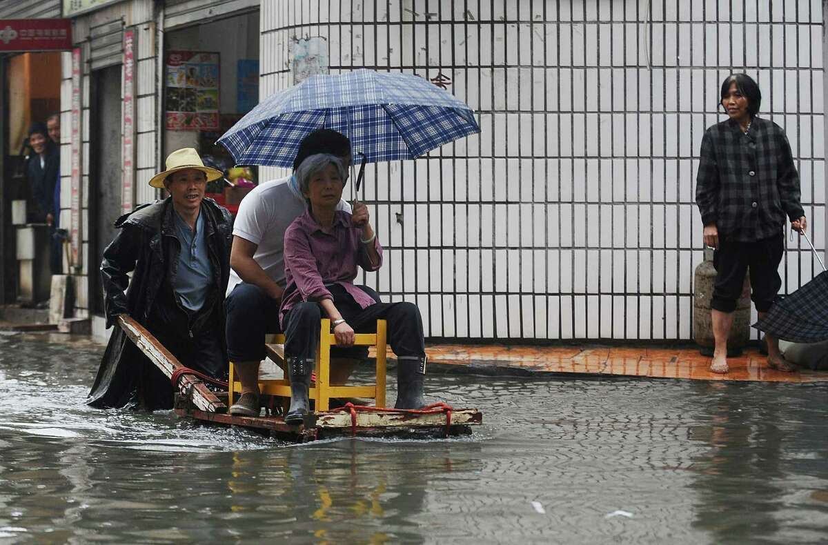 A vendor uses his cart to ferry residents across a flooded street in Wuhan, central China's Hubei province.