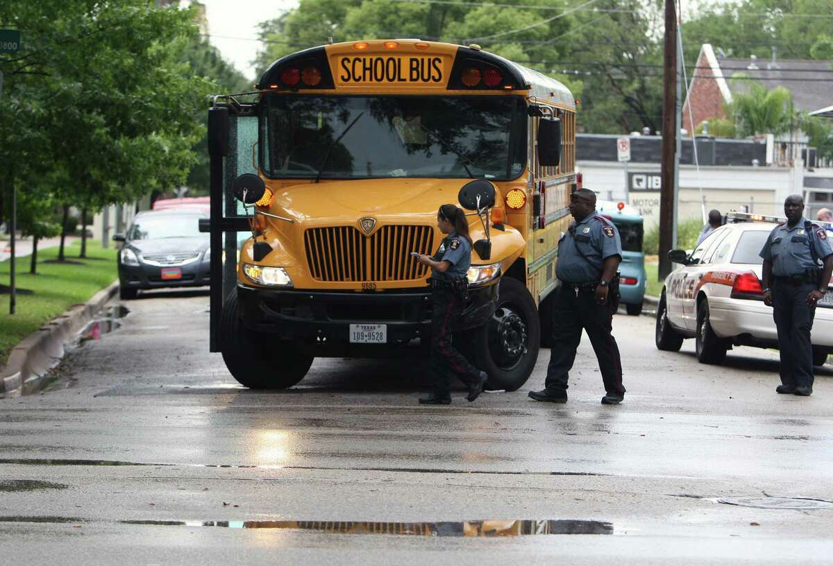 HISD officials look over a school bus which was involved in a two vehicle accident at the intersection of Montrose Boulevard and Sul Ross Street Thursday, May 31, 2012, in Houston. There were no reported injuries to the students or drivers of both vehicles.