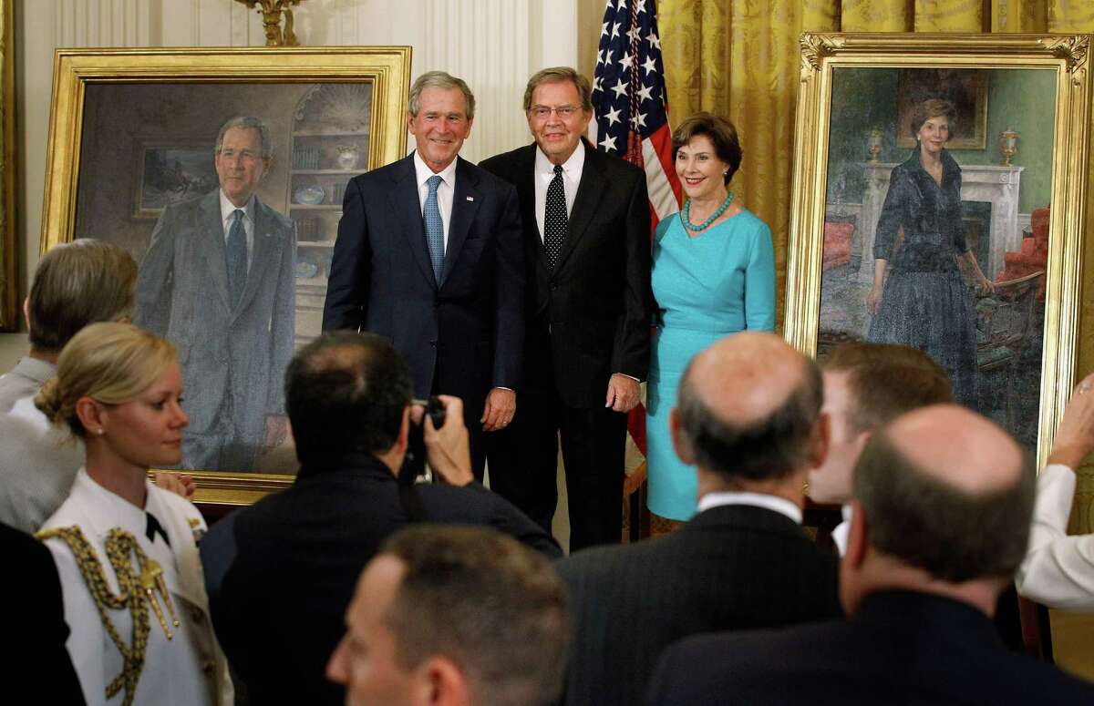 Former President George W. Bush (L) and former first lady Laura Bush (R) pose with artist John Howard Sanden during the unveiling ceremony of the Bushs' offical portraits in the East Room of the White House May 31, 2012 in Washington, DC. Commissioned by the White House Historical Association, the portraits will hang in the White House next to portraits of the other past presidents.