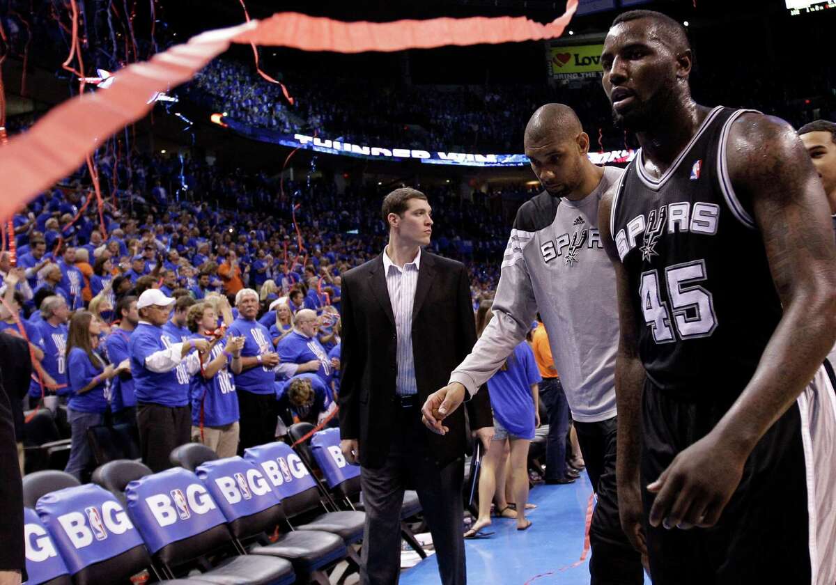 San Antonio Spurs center Tim Duncan (21) and DeJuan Blair (45) leave at the end of Game 3 in their NBA basketball Western Conference finals playoff series against the Oklahoma City Thunder, Thursday, May 31, 2012, in Oklahoma City. The Thunder won 102-82. (AP Photo/Eric Gay)
