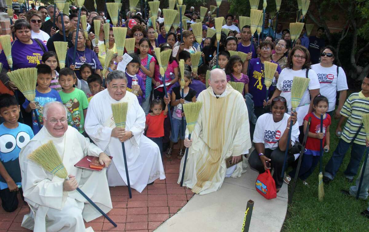 Deacon Sam Dunning, left, Deacon Joseph Rubio and Rev. Brendan Cahill, chancellor of the Houston-Galveston Archdiocese, participate in a "blessing of the brooms" mass with local janitors.