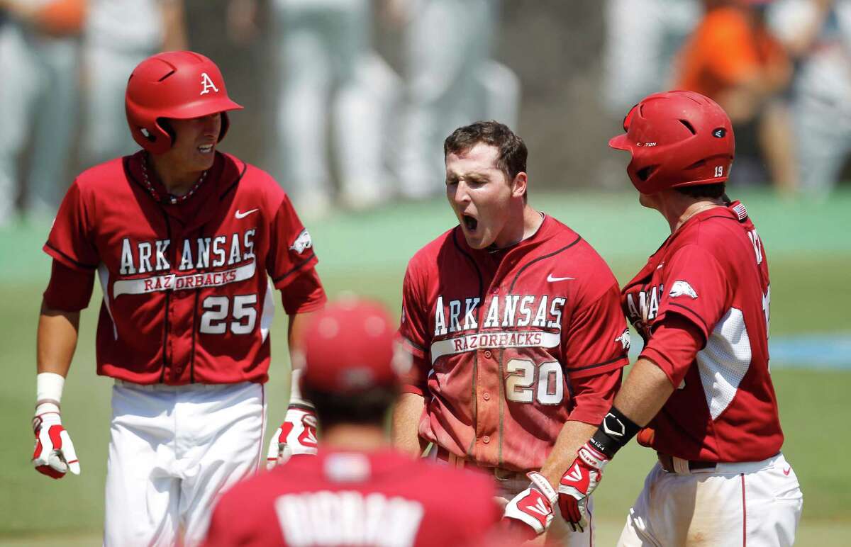 Arkansas' Matt Vinson (20) celebrates after sliding into home against Sam Houston's catcher John Hale (10) on an RBI by Tim Carver (18) in the 7th inning during a college baseball game at the Houston Regional at Rice University, Friday, June 1, 2012, in Houston. Arkansas won the game against Sam Houston 5-4.