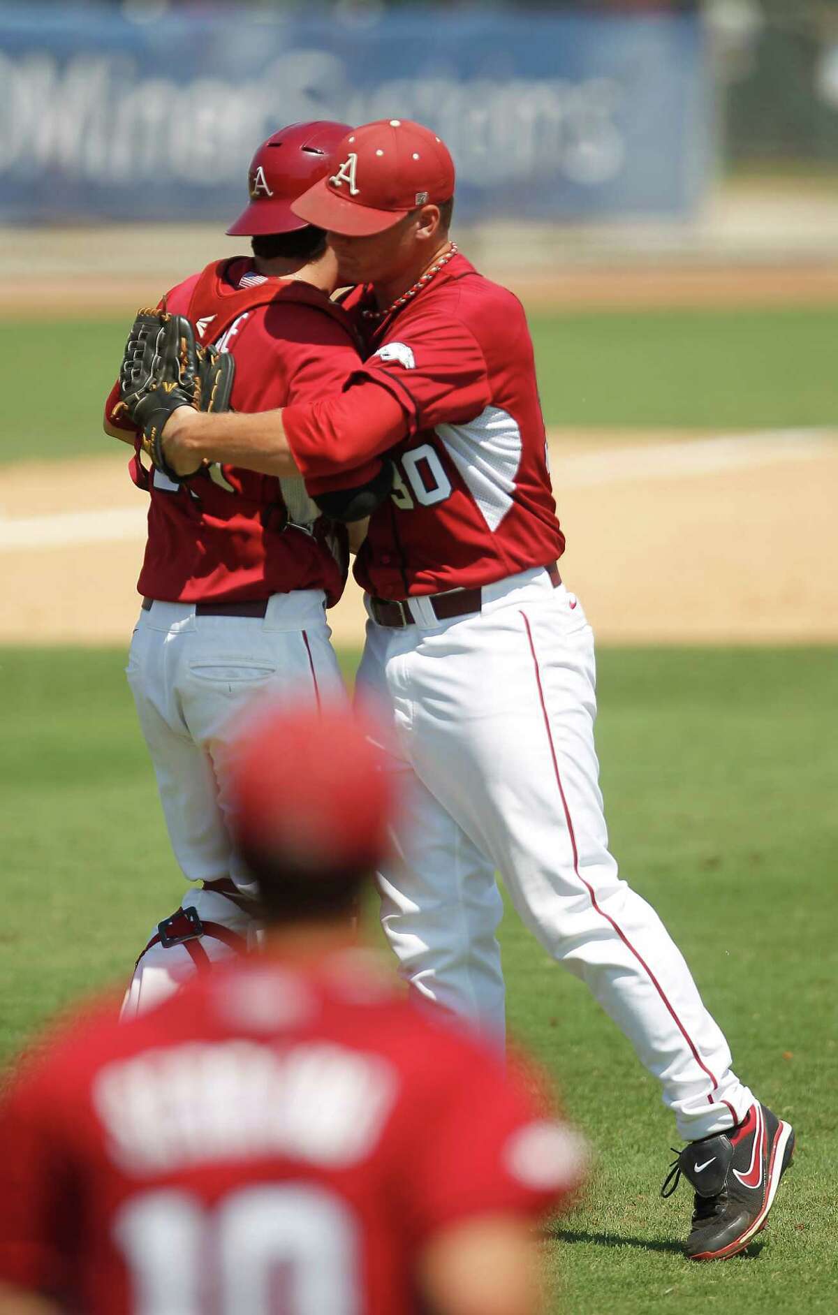 Arkansas' pitcher Brandon Moore (30) and his catcher Jake Wise (19) celebrate their win over Sam Houston 5-4 during a college baseball game at the Houston Regional at Rice University, Friday, June 1, 2012, in Houston.
