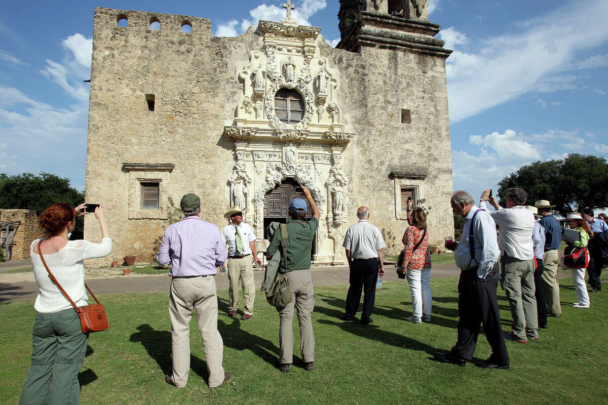 Ivan Myjer, stone conservator who worked on the restoration of the San Jose Mission chapel, addresses a large group of symposium attendees on the grounds of the San Antonio landmark to consider World Heritage Site nomination on May 31, 2012.