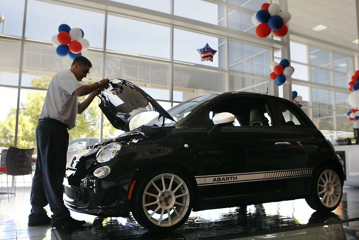 Design specialist and salesperson Matt Moore opeing the hood of the Fiat 500 Abarth at Fiat of Fremont in Newark, California, on Friday, June 1, 2012.