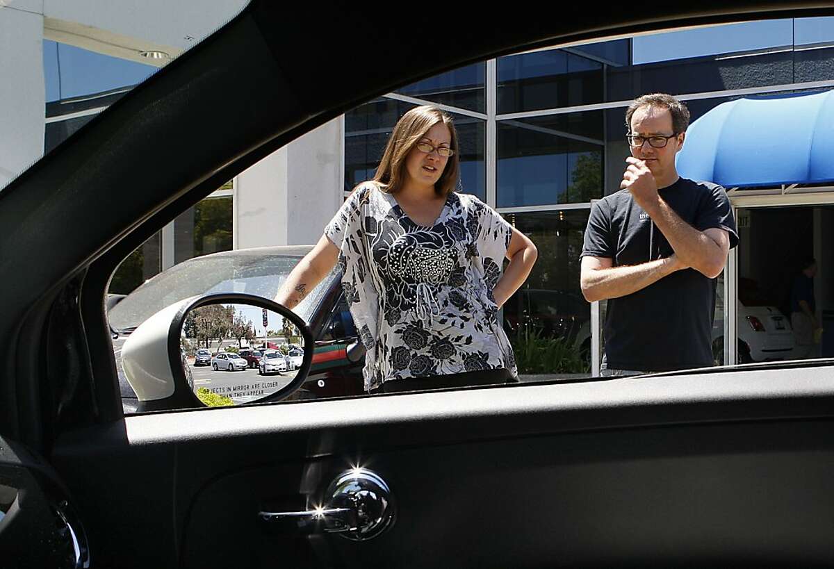 Salesperson Nicole Armstrong (left) with customer Edward Fairchild (right) from Sunnyvale, looking at the Fiat 500 Abarth at Fiat of Fremont in Newark, California, on Friday, June 1, 2012.