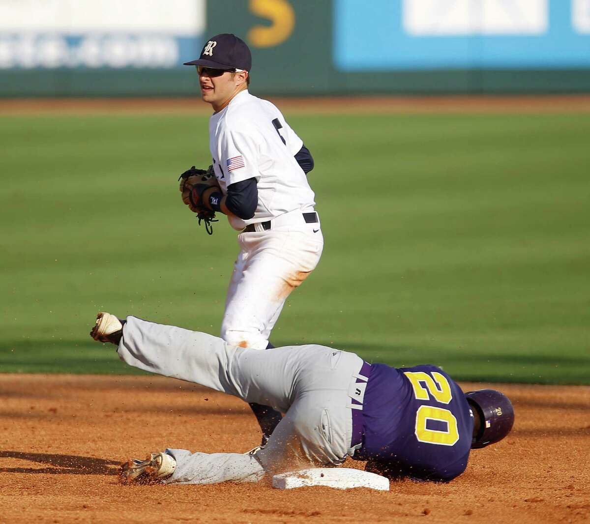 Prairie View's Evan Richard (20) lies on second base safely after a throwing error as Rice's Christian Stringer (5) tries to tag him in the 2nd inning during a college baseball game at the Houston Regional at Rice University, Friday, June 1, 2012, in Houston. Rice won the game 3-2.