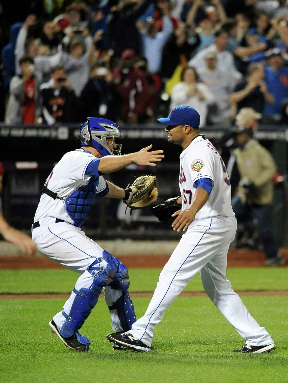 New York Mets catcher Josh Thole, left, runs to hug starting pitcher Johan Santana who threw a no-hitter against the St. Louis Cardinals in a baseball game on Friday, June 1, 2012, at Citi Field in New York.
