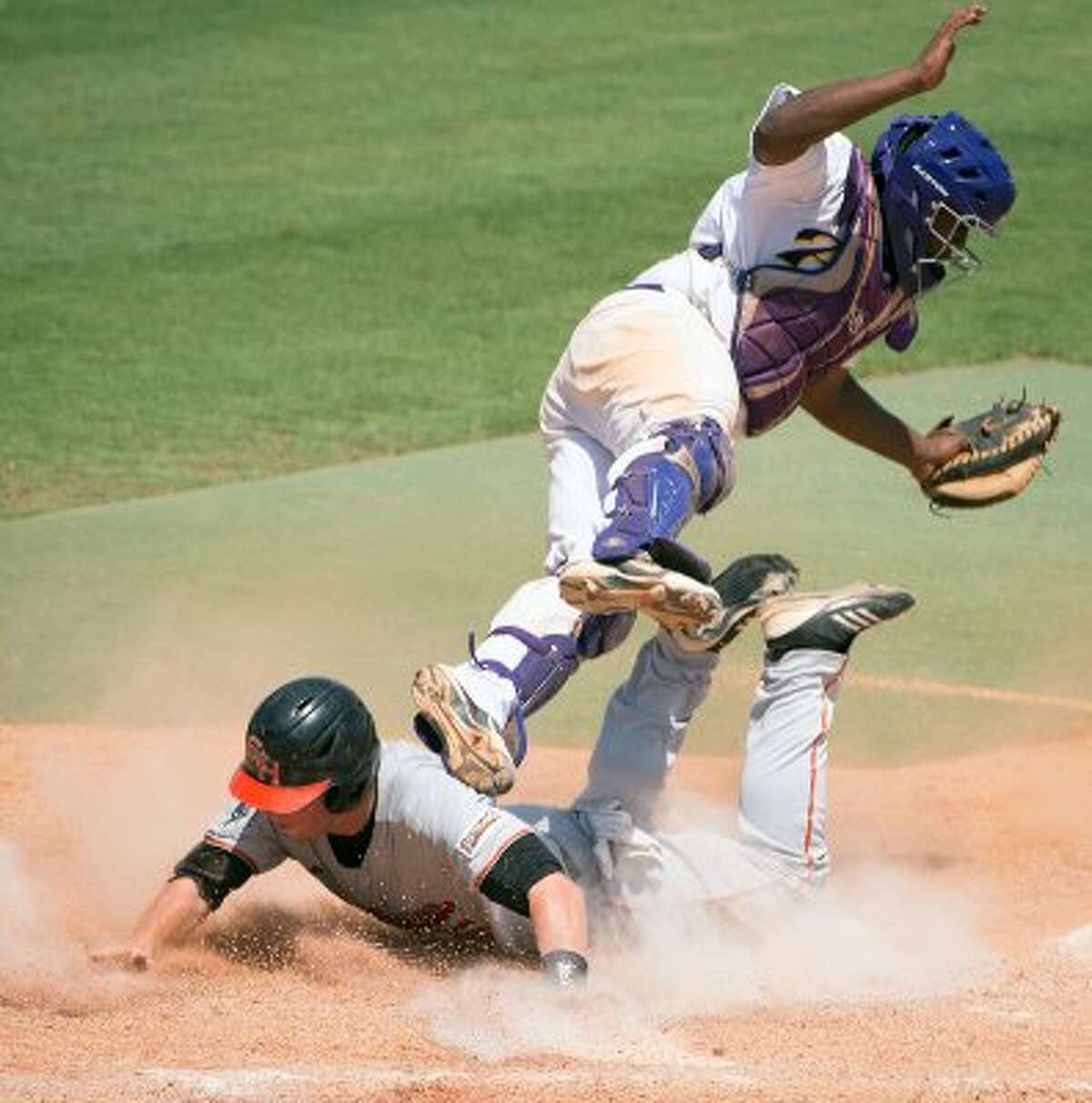 Sam Houston State second baseman Jessie Plumlee slides safely into home as Prairie View catcher Evan Richard tumbles over him during the ninth inning of an NCAA college baseball tournament regional game Saturday, June 2, 2012, in Houston. Sam Houston State won the game 4-2. ( Smiley N. Pool / Houston Chronicle ) (Smiley N. Pool / Houston Chronicle)