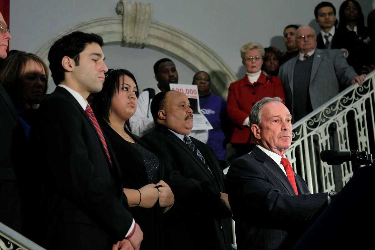 New York City Mayor Michael Bloomberg, right, joined by family and friends of those injured and killed in the shootings in Tucson, Ariz., at Virginia Tech and Columbine High School in Colorado, speaks about gun control during a news conference at City Hall in New York, Monday, Jan. 24, 2011. (AP Photo/Seth Wenig)