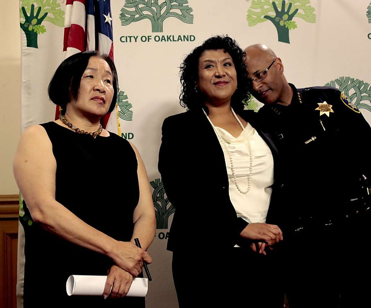 Mayor Jean Quan listens to questions from the media as the Chief of Police Howard Jordan whispers to City Administrator Deanna J. Santana, during a press conference at City Hall, Monday April 23, 2012, announcing the police departments crowd management reform to help with the way officers interact with Occupy Oakland in Oakland, Calif.