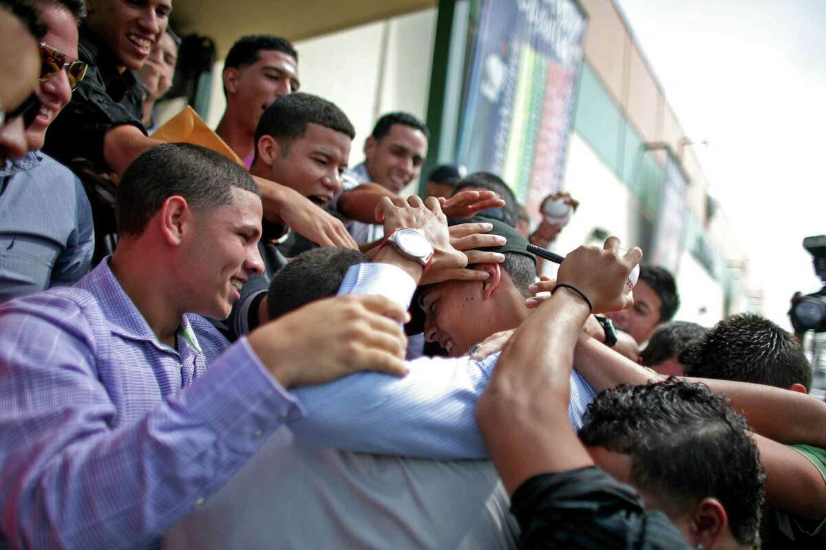 Student and baseball player Carlos Correa, center, is greeted by classmates upon his arrival to the Puerto Rico Baseball Academy High School in Caguas, Puerto Rico, Tuesday, June 5, 2012. Correa, the 17-year-old slugging shortstop made hometown history on Monday after being selected by the Houston Astros as No. 1 in the Major League Baseball draft, becoming the first No. 1 overall pick from Puerto Rico. (AP Photo/Ricardo Arduengo)