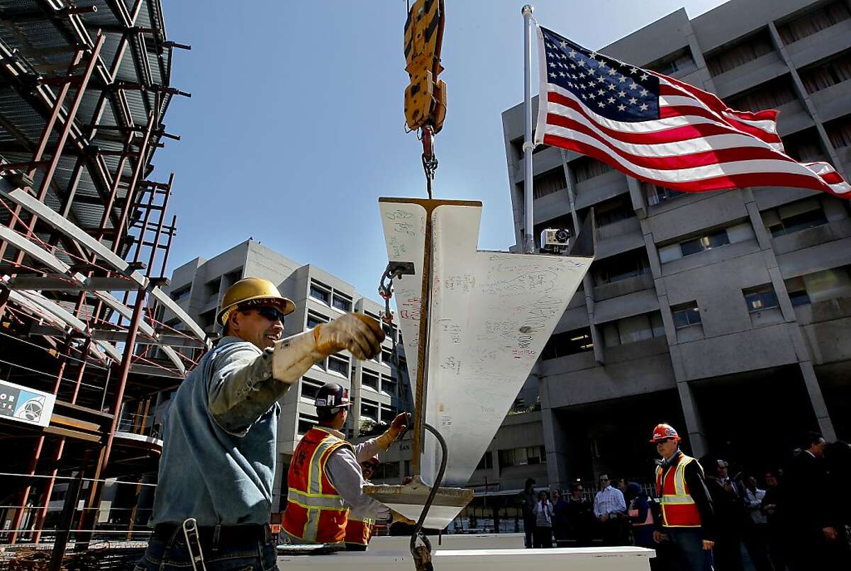 Irons worker Nick Grey guides the bean as they prepare to lift the final beam into place, as San Francisco General Hospital celebrates a milestone in the rebuild of it's care facility with the topping out ceremony on Tuesday June 5, 2012, in San Francisco, Ca.