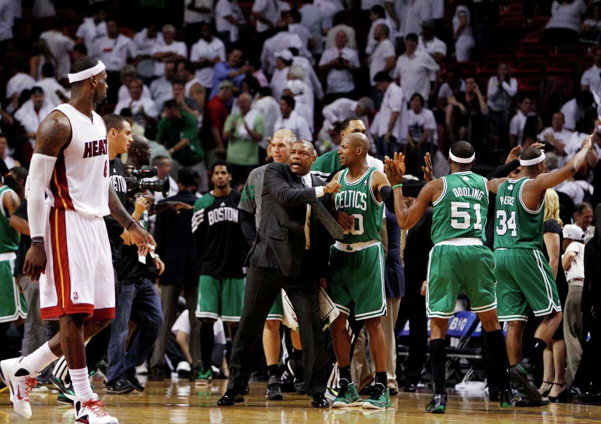 Boston Celtics head coach Doc Rivers, center, celebrates with Ray Allen (20), Keyon Dooling (51) and Paul Pierce (34) as Miami Heat's LeBron James, left, walks past during the second half of Game 5 in their NBA basketball Eastern Conference Finals playoff series, Tuesday, June 5, 2012, in Miami. The Celtics won 94-90. (AP Photo/Lynne Sladky)