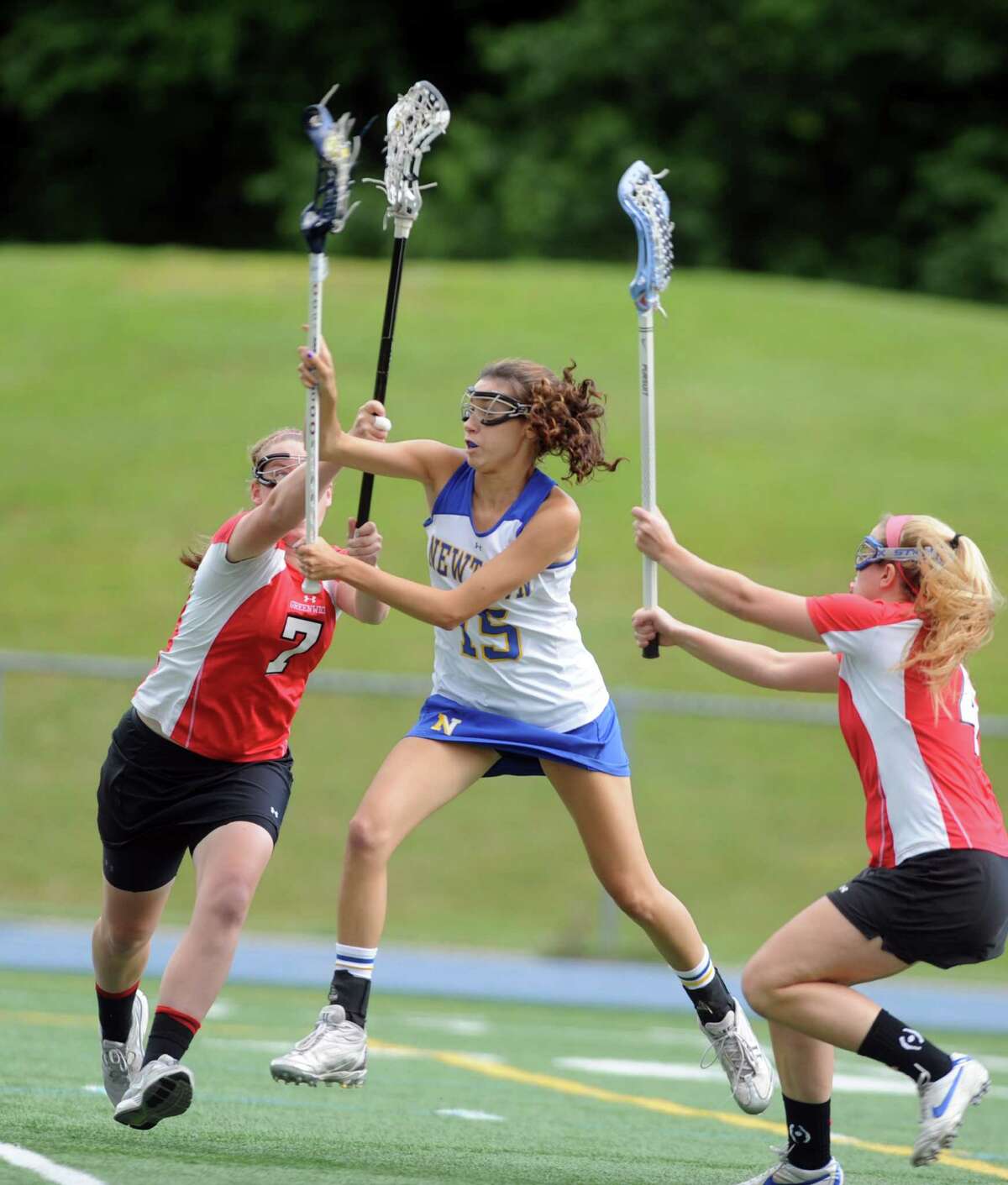 Newtown's Erin Kenning takes a shot on goal as Greenwich's defenders Shannon Colligan, left, and Isabelle Mackell surround her during the Girls Lacrosse State Tournament Class L Semifinals Wednesday, June 6, 2012 at Bunnell High School in Stratford, Conn.